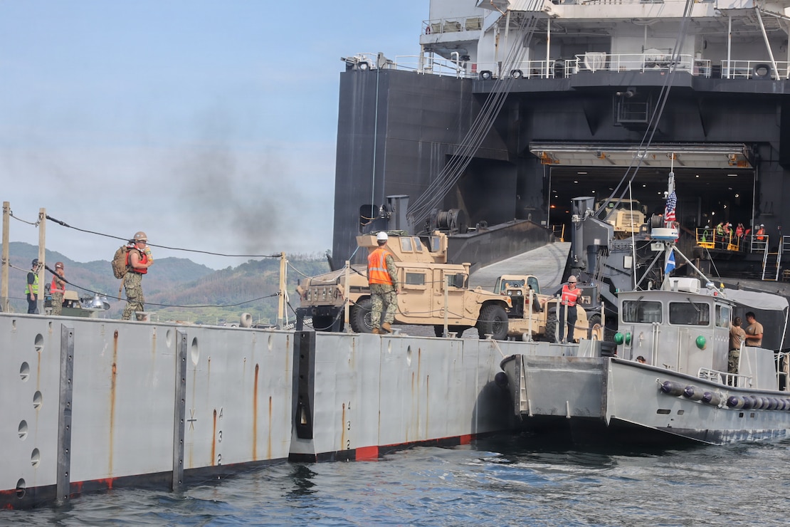 U.S. service members transfer a High Mobility Multipurpose Wheeled Vehicle onto an Improved Navy Lighterage System to conduct a cargo offload during Combined Joint Logistics Over-the-Shore 26 at Dogu Beach, Pohang, South Korea, July 9, 2026. The offload was a Maritime Prepositioning Force exercise where 3rd Marine Logistics Group distributes equipment from a created port of entry and provides support to III Marine Expeditionary Force units training throughout South Korea, testing and validating 3rd MLG’s ability to conduct integrated logistics operations in complex environments. CJLOTS 26 is a combined exercise designed to integrate U.S. and Republic of Korea lighterage and ship-to-shore connector capabilities, improve combined readiness, strengthen the Republic of Korea-U.S. alliance, and expand combined maritime sustainment capacity during logistics operations. (U.S. Marine Corps photo by Lance Cpl. Matthew Borruso)