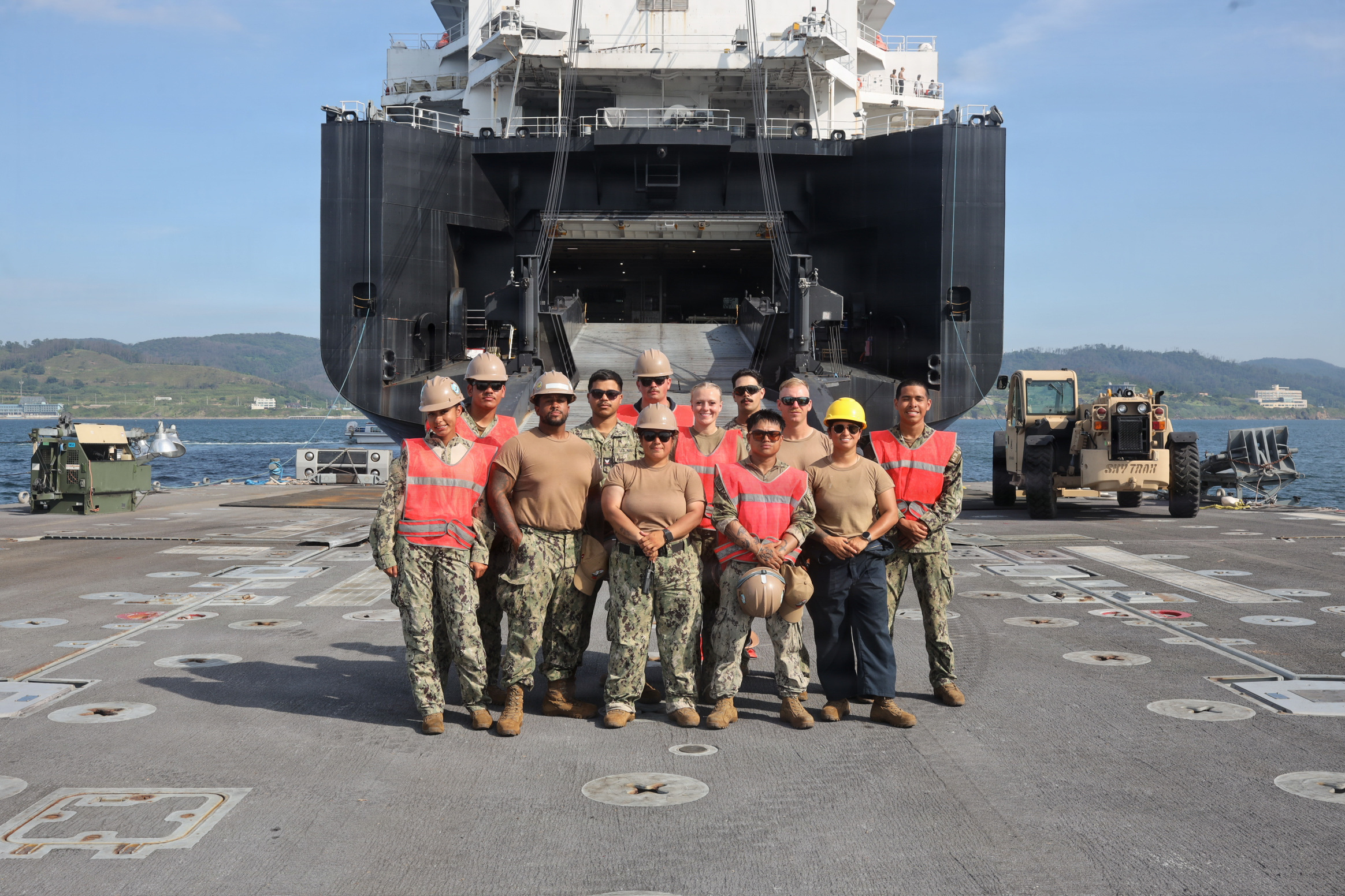 U.S. service members pose for a group photo following a cargo offload for Combined Joint Logistics Over-the-Shore 26 at Dogu Beach, Pohang, South Korea, July 9, 2026. The offload was a Maritime Prepositioning Force exercise where 3rd Marine Logistics Group distributes equipment from a created port of entry and provides support to III Marine Expeditionary Force units training throughout South Korea, testing and validating 3rd MLG’s ability to conduct integrated logistics operations in complex environments. CJLOTS 26 is a combined exercise designed to integrate U.S. and Republic of Korea lighterage and ship-to-shore connector capabilities, improve combined readiness, strengthen the Republic of Korea-U.S. alliance, and expand combined maritime sustainment capacity during logistics operations. (U.S. Marine Corps photo by Lance Cpl. Matthew Borruso)