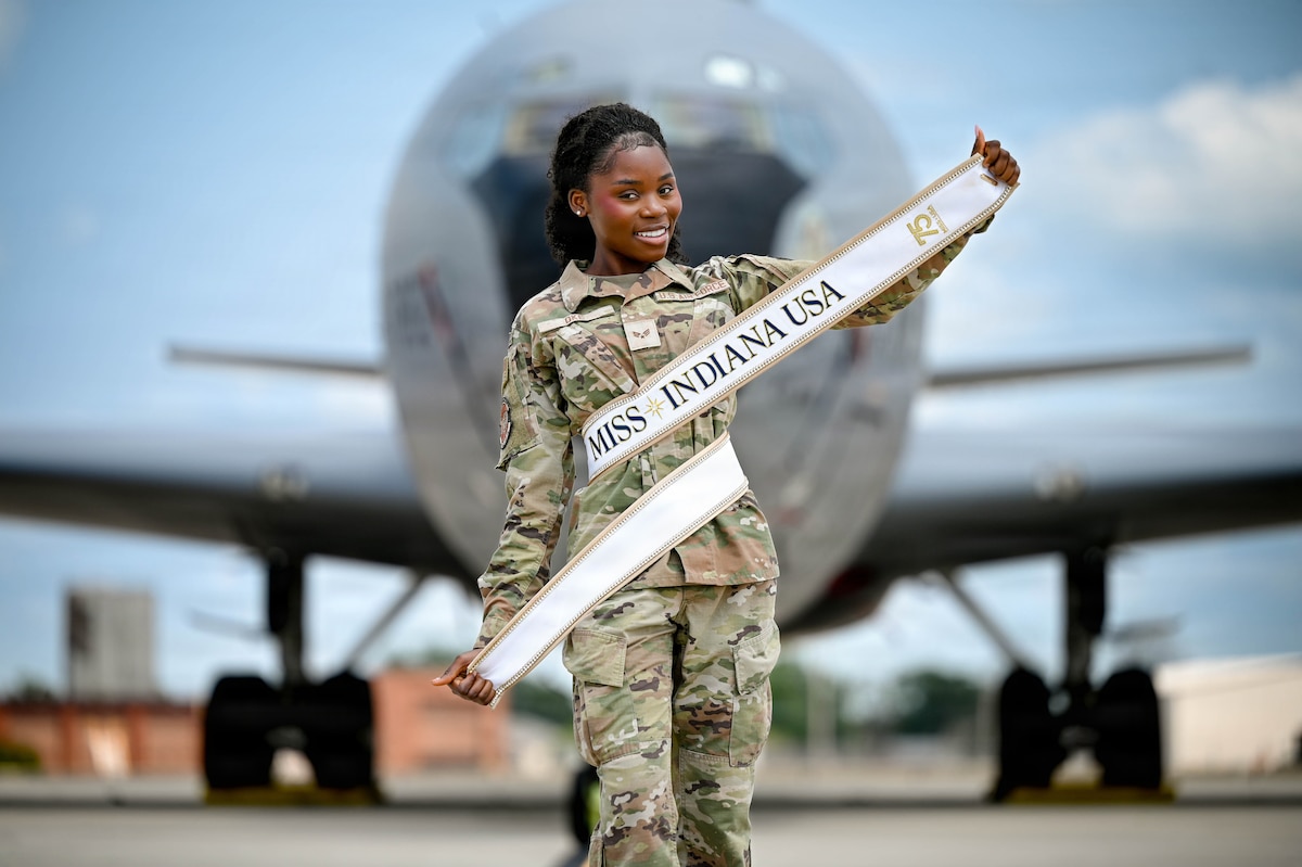 Airman poses in front of an aircraft