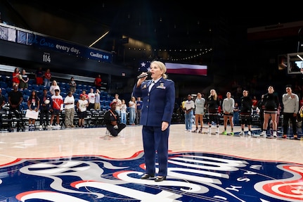 U.S. Air Force Maj. Karen Fraley-Deegan, Military Personnel Management Officer, 113th Wing, District of Columbia Air National Guard, performs the National Anthem during pregame ceremonies before a Washington Mystics game at CareFirst Arena, July 16, 2026. Fraley-Deegan has performed the National Anthem at promotions, retirements, change of command ceremonies, inter-service transfers, military commemorations, and civic events, using her voice to honor those who serve, strengthen esprit de corps, and tell the nation's story through song.