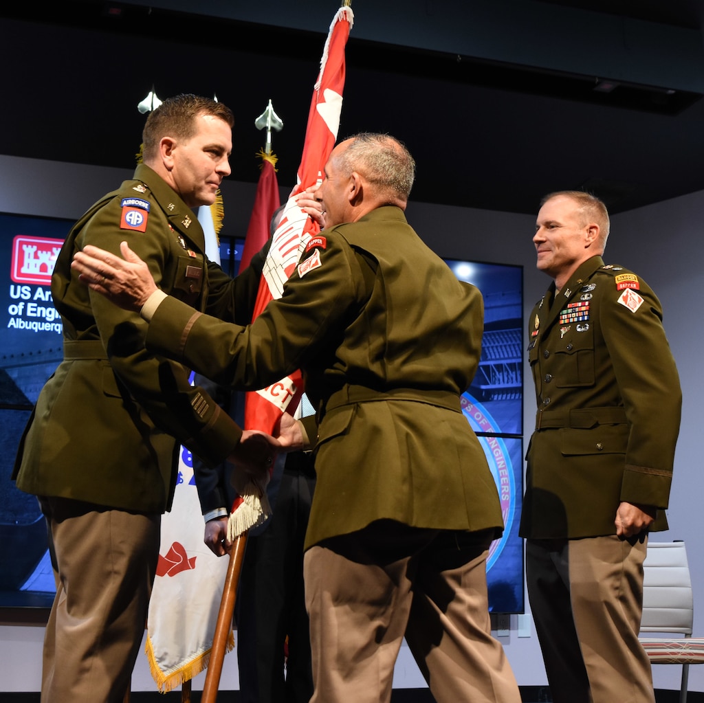 Brig. Gen. John Lloyd, center, commander, USACE-South Pacific Division, passes the USACE flag to USACE-Albuquerque District Commander Lt. Col. Brian Williams, left, during the change of command ceremony in Albuquerque, N.M., July 24, 2026. Outgoing Albuquerque District Commander Lt. Col. Matthew Miller, right, looks on.