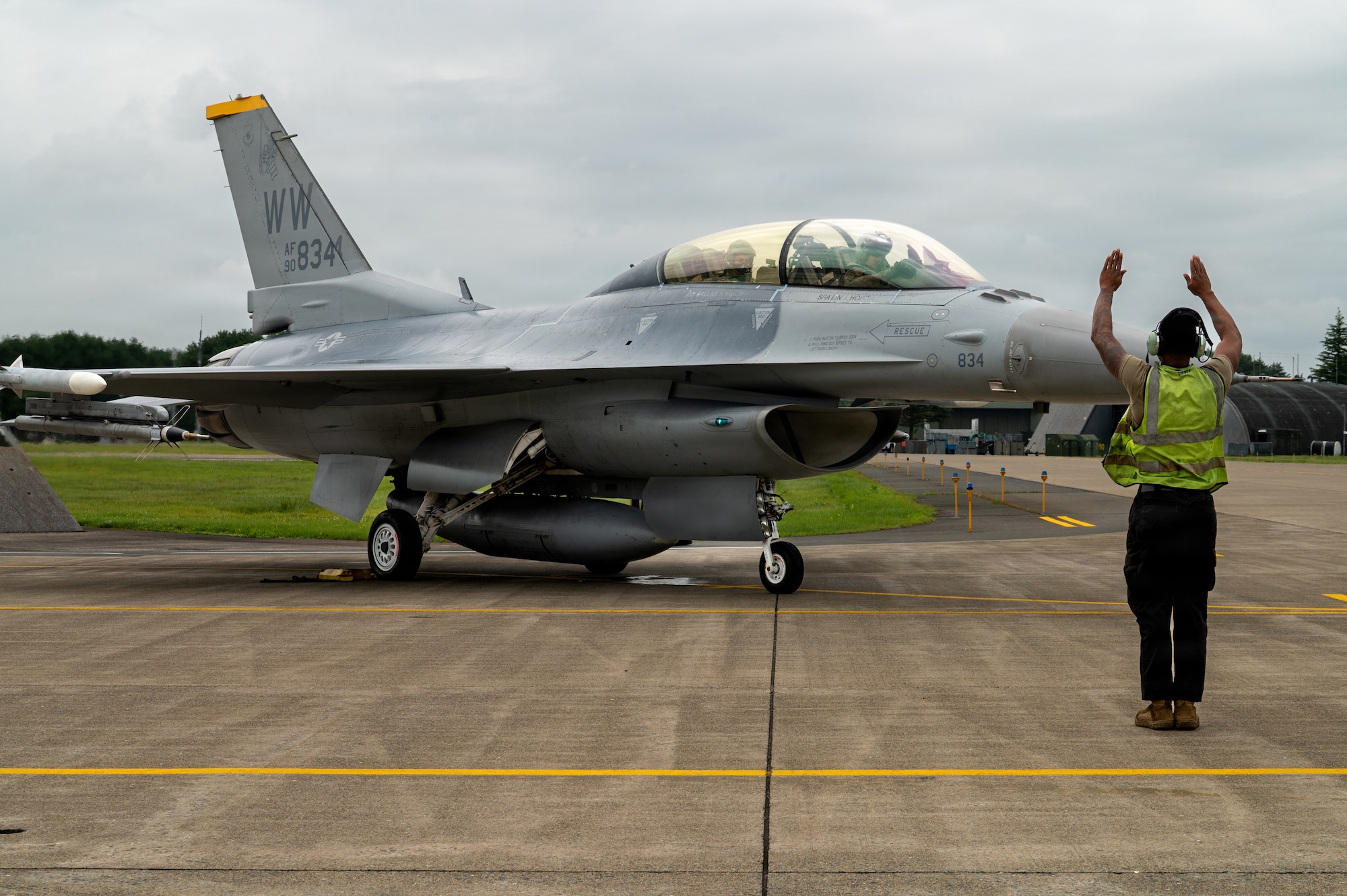 A U.S. Air Force crew chief marshals a USAF F-16 Fighting Falcon piloted by Japan Air Self-Defense Force Lt. Gen. Keita Funakura, Northern Air Defense Force commander, and U.S. Air Force Col. Jeromy Guinther, 35th Operations Group commander, before a familiarization flight at Misawa Air Base, Japan, July 27, 2026.