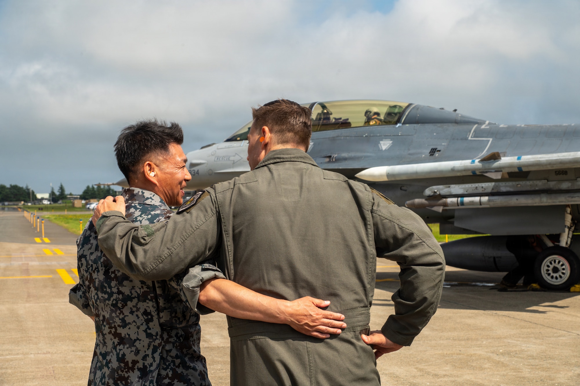 U.S. Air Force Col. Oliver Lause, 35th Fighter Wing commander, embraces a Japan Air Self-Defense Force member while awaiting the arrival of JASDF Lt. Gen. Keita Funakura, Northern Air Defense Force commander, following a USAF F-16 Fighting Falcon familiarization flight at Misawa Air Base, Japan, July 27, 2026.