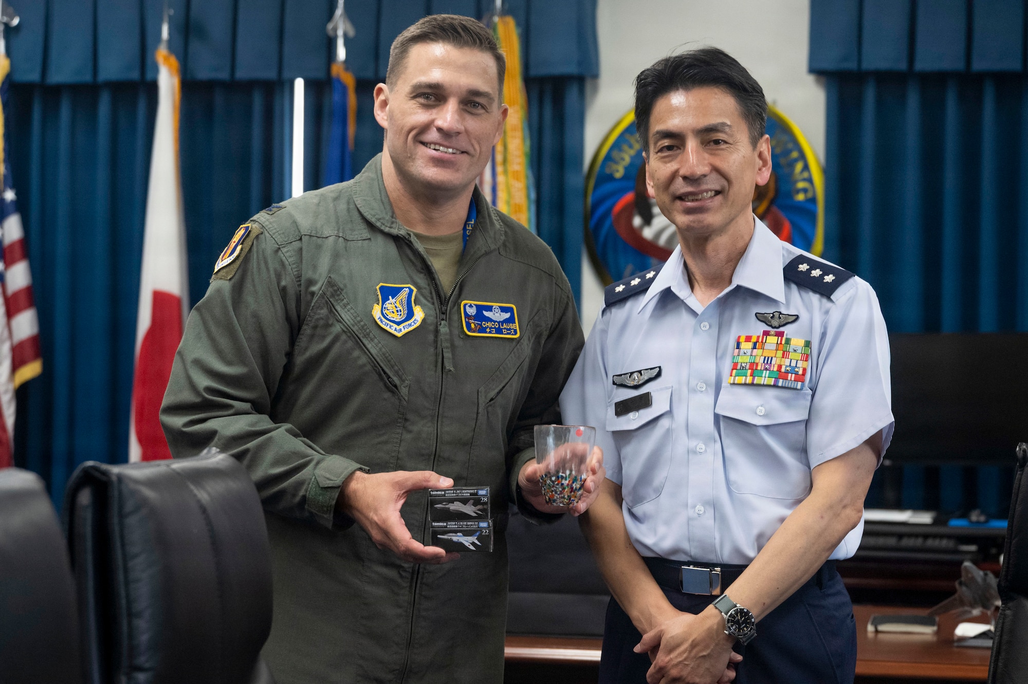 U.S. Air Force Col. Oliver Lause, left, 35th Fighter Wing commander, and Japan Air Self-Defense Force Lt. Gen. Keita Funakura, Northern Air Defense Force commander, exchange farewell and welcome gifts at Misawa Air Base, Japan, July 28, 2026.