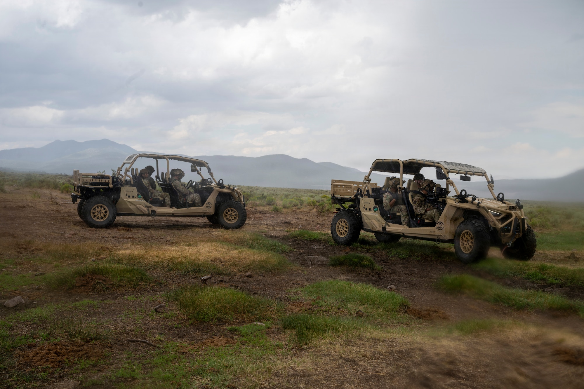 Two military vehicles are operated by Airmen during training.