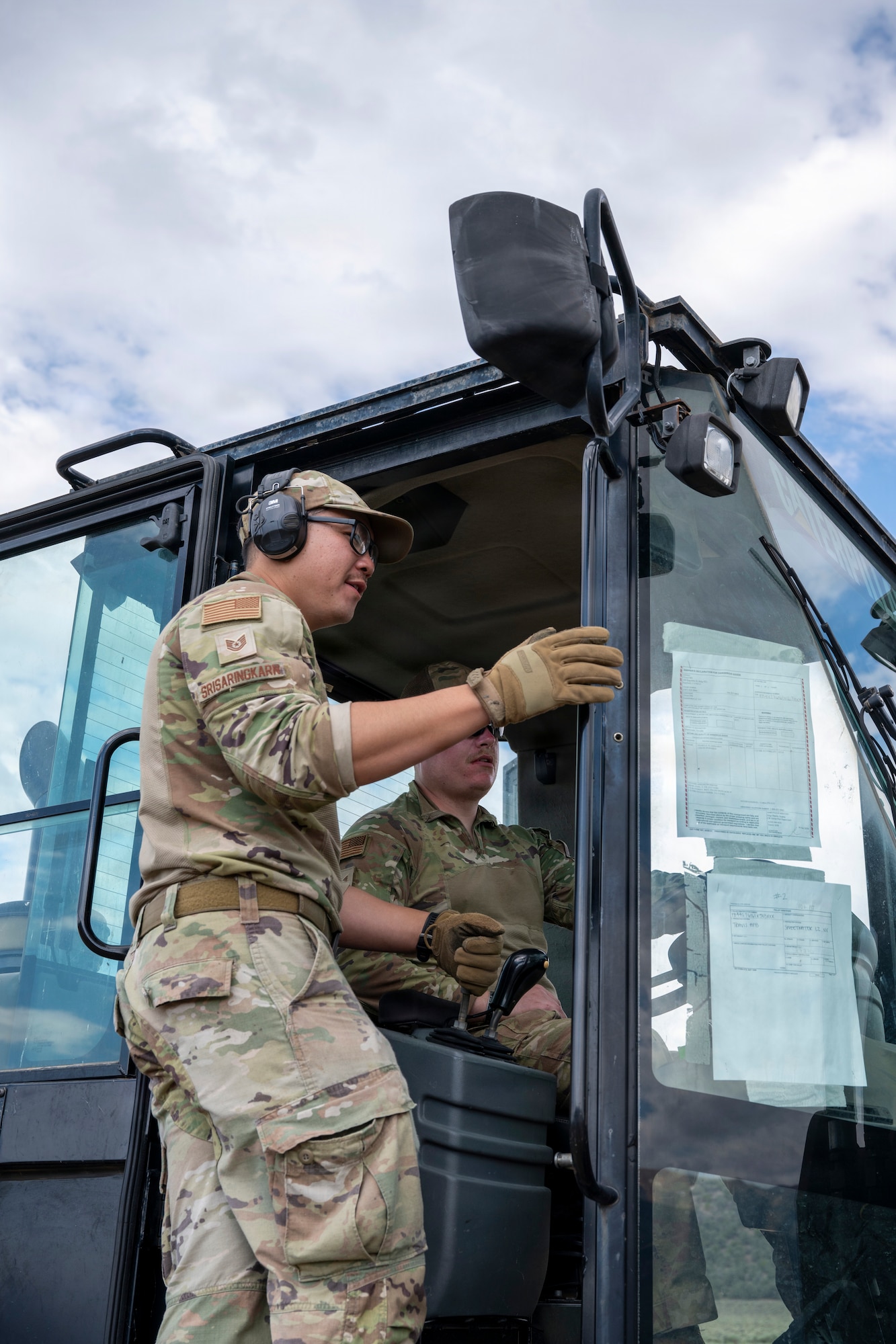 Two Airmen operate a forklift.