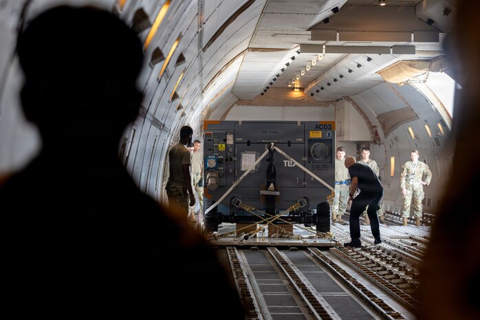 U.S. Air Force Senior Airman Jaylan Santiago, 35th Logistics Readiness Squadron logistic planner, front, manages a control panel for cargo loading onto a Boeing 747 transport aircraft in support of Red Flag-Alaska 26-3.