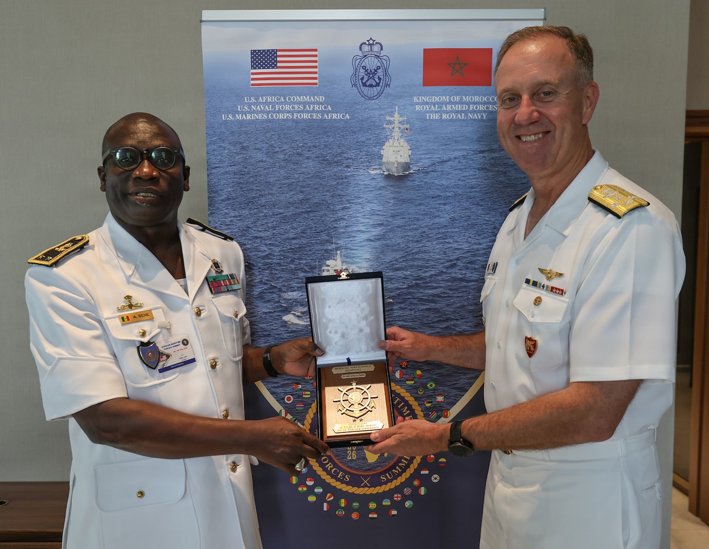 Adm. George Wikoff, Commander, U.S. Naval Forces Europe and Africa exchanges gifts with Rear Adm. Abdou Sene, Chief of Staff of the Senegalese Navy, during the African Maritime Forces Summit (AMFS).
