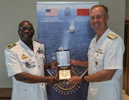Adm. George Wikoff, Commander, U.S. Naval Forces Europe and Africa exchanges gifts with Rear Adm. Abdou Sene, Chief of Staff of the Senegalese Navy, during the African Maritime Forces Summit (AMFS).