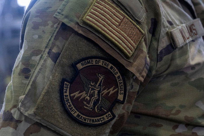 A U.S. Air Force Airman assigned to the 35th Aircraft Maintenance Squadron (AMXS) stands in formation with the 35th AMXS patch displayed during the 35th AMXS activation ceremony at Misawa Air Base Japan, July 17, 2026.