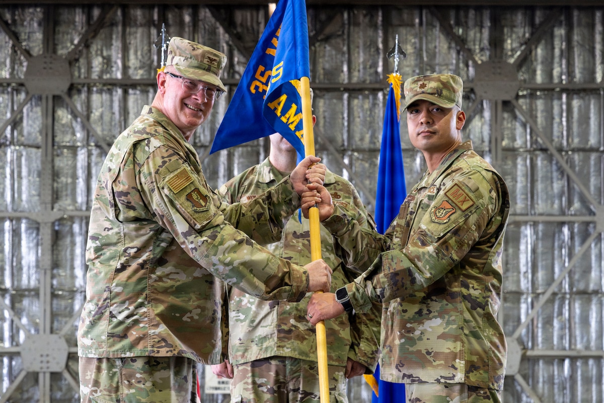 U.S. Air Force Col. Kenneth Beebe, left, 35th Maintenance Group commander, passes the 35th Aircraft Maintenance Squadron (AMXS) guidon to Maj. Alex Carmona, 35th AMXS commander, during the 35th AMXS activation ceremony at Misawa Air Base Japan, July 17, 2026.