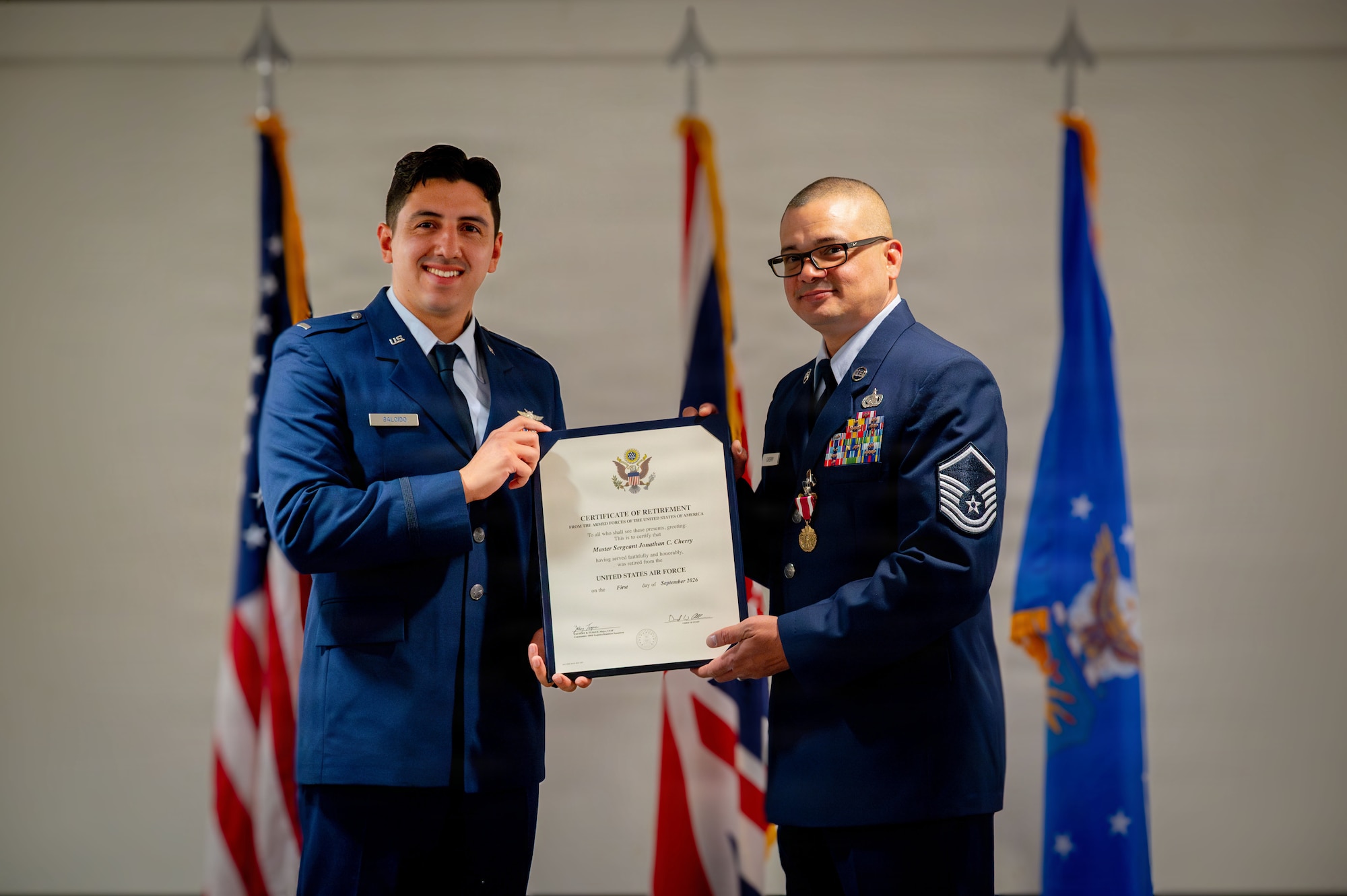 U.S. Air Force Master Sgt. Jonathan Cherry, 100th Logistics Readiness Squadron fuels flight chief, receives his certificate of retirement from 1st Lt. Anthony Salcido, 606th Air Control Squadron flight commander, during his retirement ceremony at RAF Mildenhall, England, July 9, 2026.