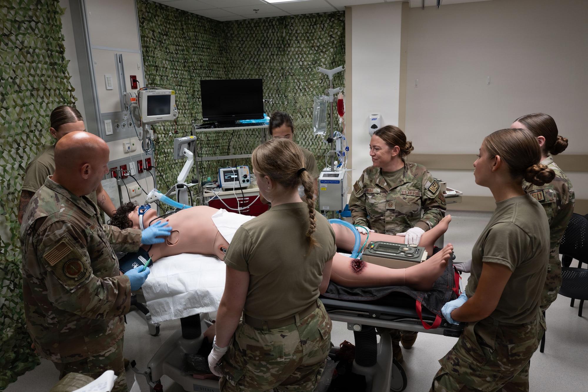 A group of Airmen stand around a training dummy while learning the equipment provided by Aviano's 31 Fighter Wing Medical Group.
