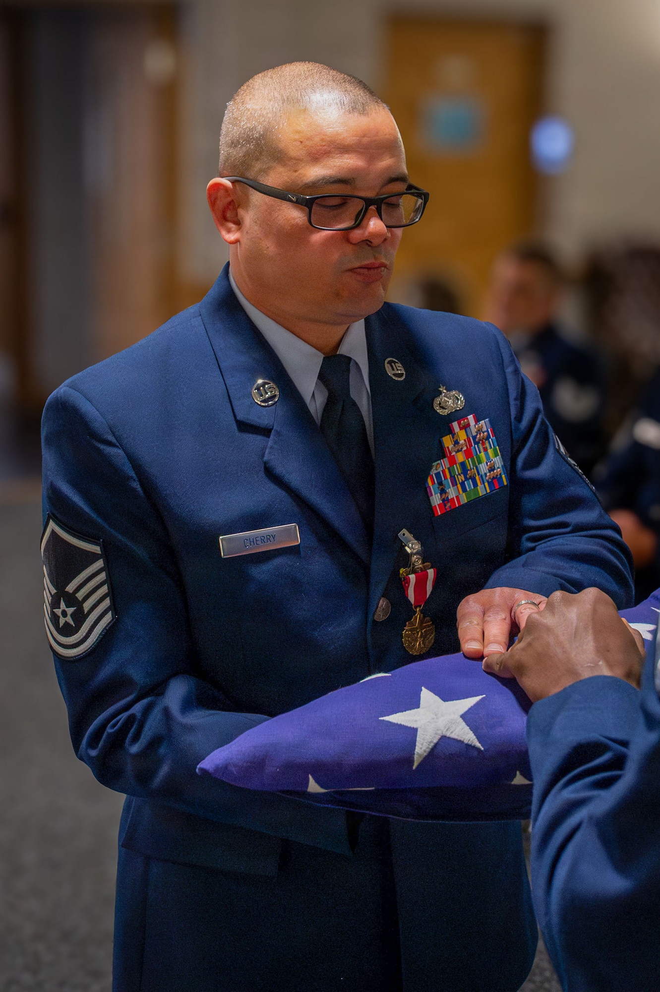 U.S. Air Force Master Sgt. Jonathan Cherry, 100th Logistics Readiness Squadron fuels flight chief, receives a folded flag during his retirement ceremony at RAF Mildenhall, England, July 9, 2026.