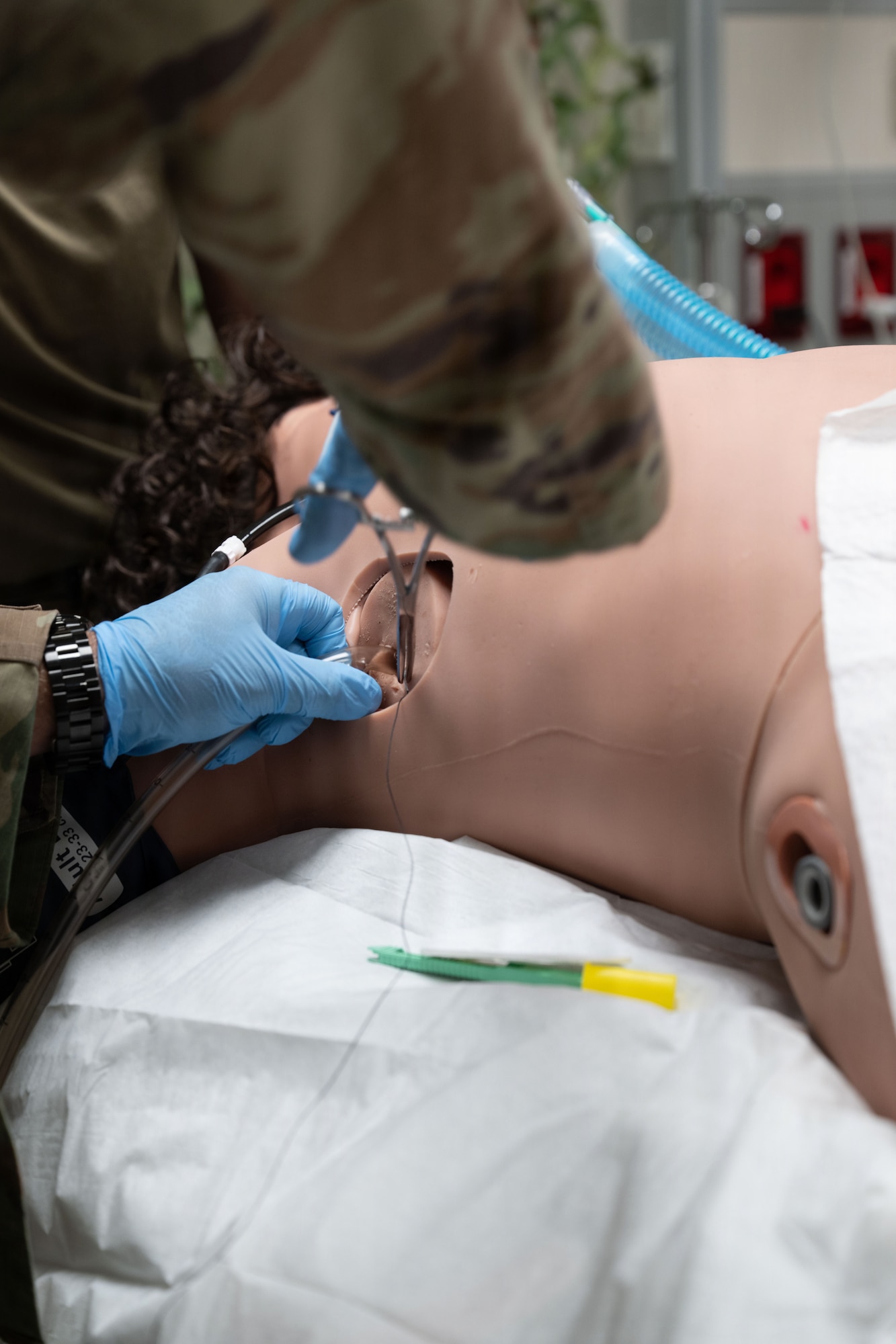 An Airman uses surgery tools to demonstrate placing a chest tube during a training.