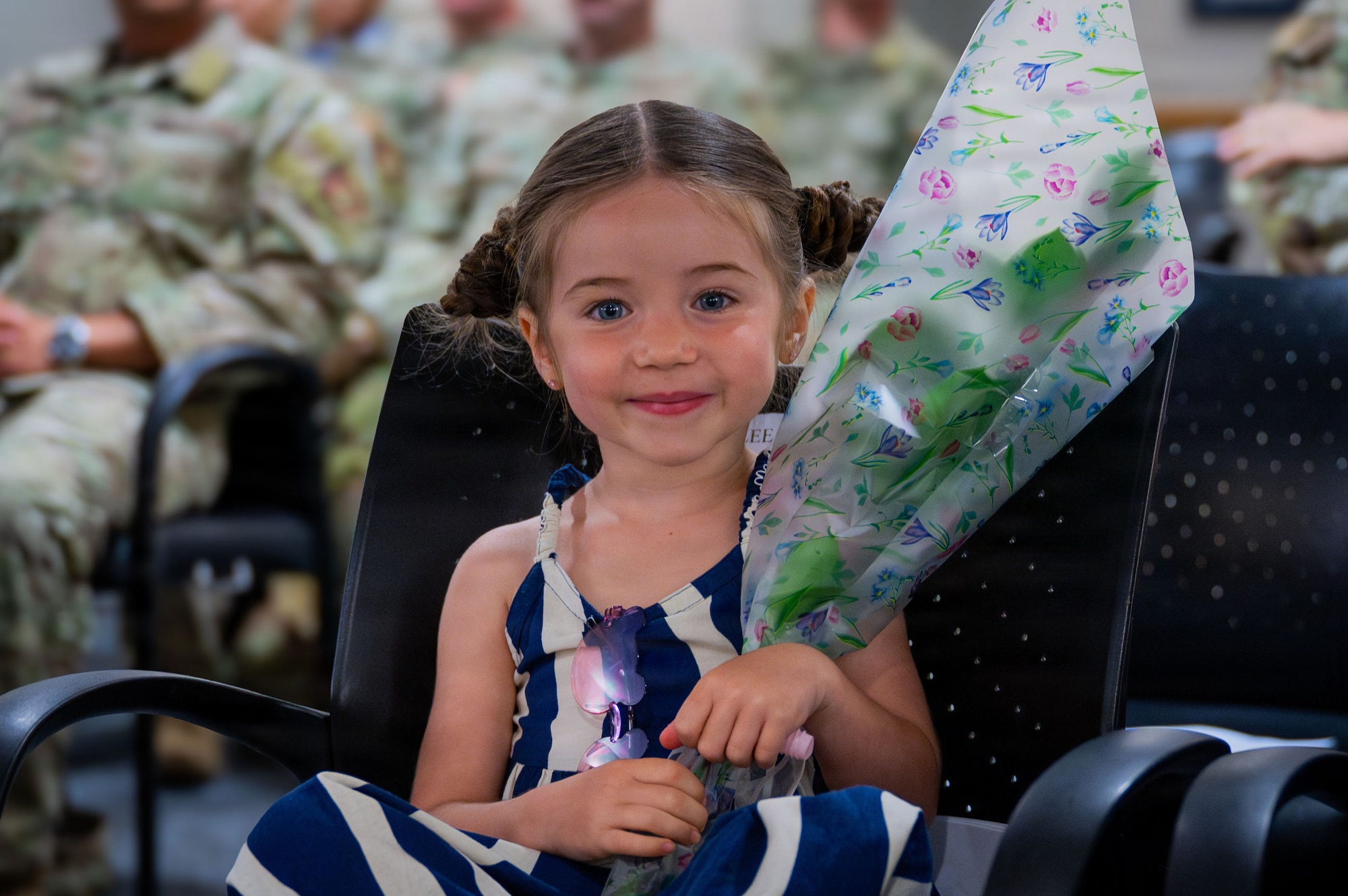 Cailee Cherry, daughter of U.S. Air Force Master Sgt. Jonathan Cherry, poses with flowers during his retirement ceremony at RAF Mildenhall, England, July 9, 2026.