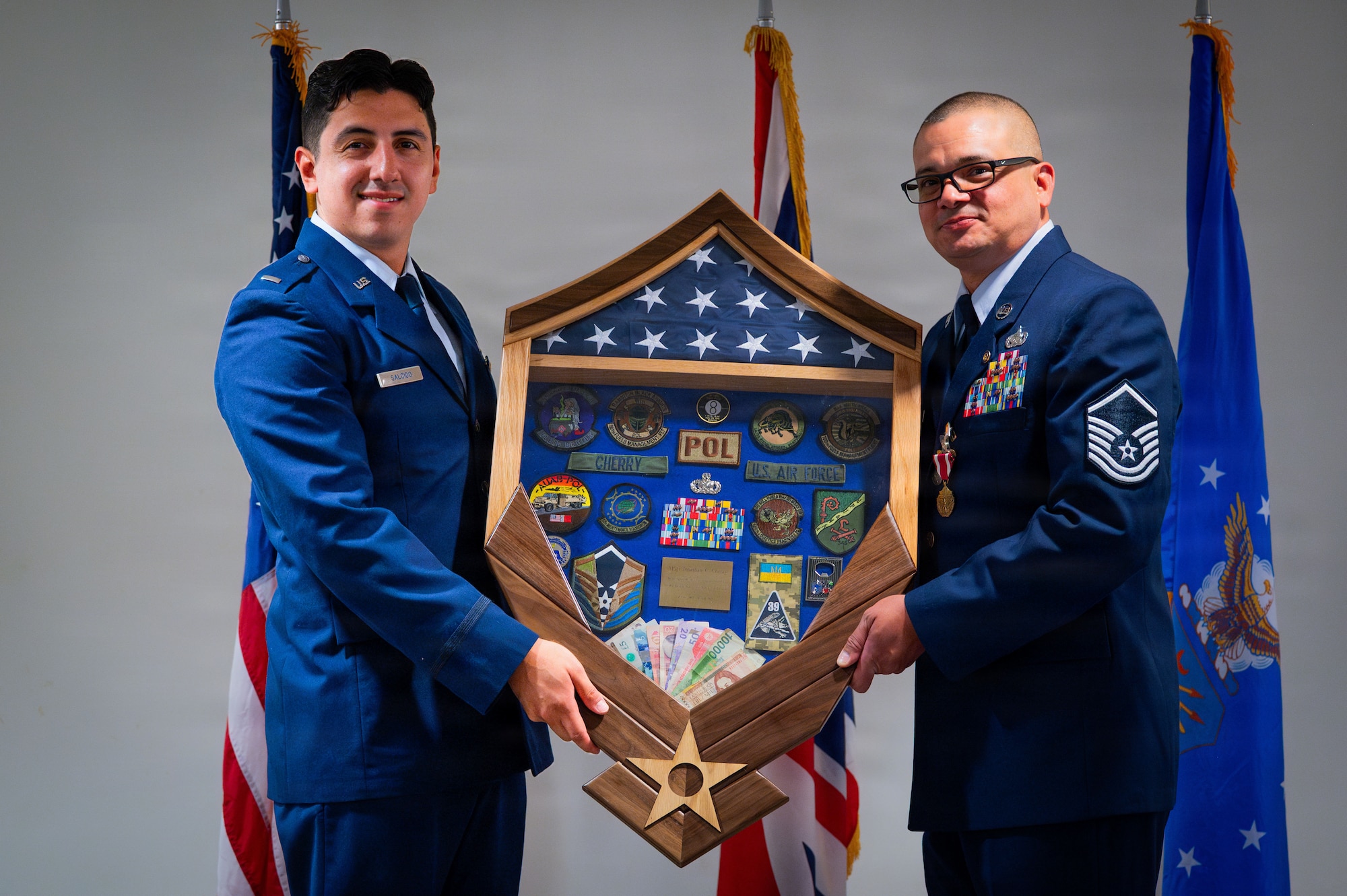 U.S. Air Force Master Sgt. Jonathan Cherry, 100th Logistics Readiness Squadron fuels flight chief, receives a shadow box from 1st Lt. Anthony Salcido, 606th Air Control Squadron flight commander, during his retirement ceremony at RAF Mildenhall, England, July 9, 2026.