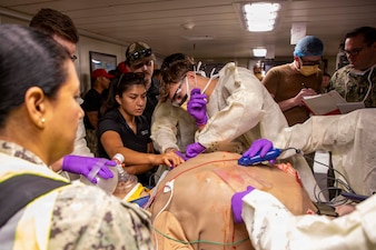 Sailors assigned to the Expeditionary Medical Unit (EMU-2) perform needle thoracostomy on a medical dummy during an Operational Readiness Evaluation (ORE) aboard the expeditionary fast transport ship USNS Point Loma (T-EPF 15), July 25, 2026. The event marked the Navy’s first ORE conducted for an EMU, and the first afloat ORE for the Navy’s expeditionary medical capability, a critical step in validating deployable medical capabilities in support of maritime operations, distributed maritime operations, and warfighter readiness. (U.S. Navy photo by Mass Communication Specialist 1st Class Nathan T. Beard)