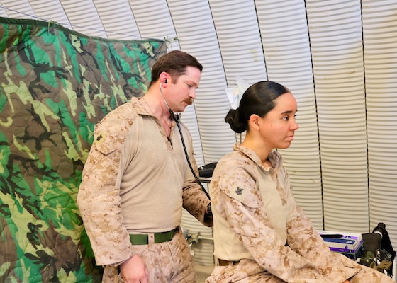Hospital Corpsman 1st Class James C. Radecki (left), assigned to Navy Medicine Readiness and Training Command Twentynine Palms, demonstrates sick call procedures on a Sailor at the Consolidated Aid Station (CAS) during Integrated Training Exercise (ITX) 3-26 at Camp Wilson aboard Marine Air-Ground Task Force Training Command/Marine Corps Air Ground Combat Center Twentynine Palms. Radecki helped train dozens of corpsmen from commands across the country to conduct sick call operations in support of the exercise. (U.S. Navy photo by Christopher Jones, NH/NMRTC Twentynine Palms public affairs officer).