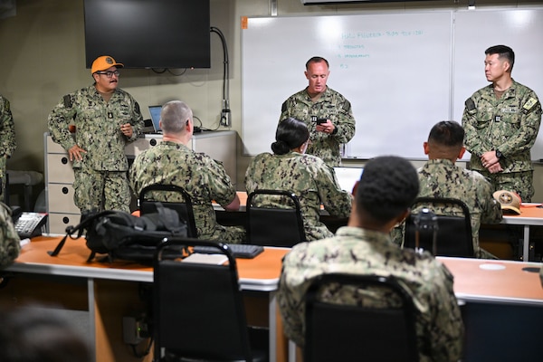 Lt. Kyle Keeler, a subject matter expert supporting the U.S. Navy's first expeditionary medical unit (EMU) operational readiness evaluation (ORE) aboard the expeditionary fast ship USNS Point Loma (T-EPF 15), reads feedback to Sailors assigned to EMU-2, July 26, 2026. The EMU ORE marks a critical step in validating deployable medical capability in support of maritime operations, distributed maritime operations, and warfighter readiness. (U.S. Navy photo by Mass Communication Specialist 1st Class Shayla D. Hamilton)