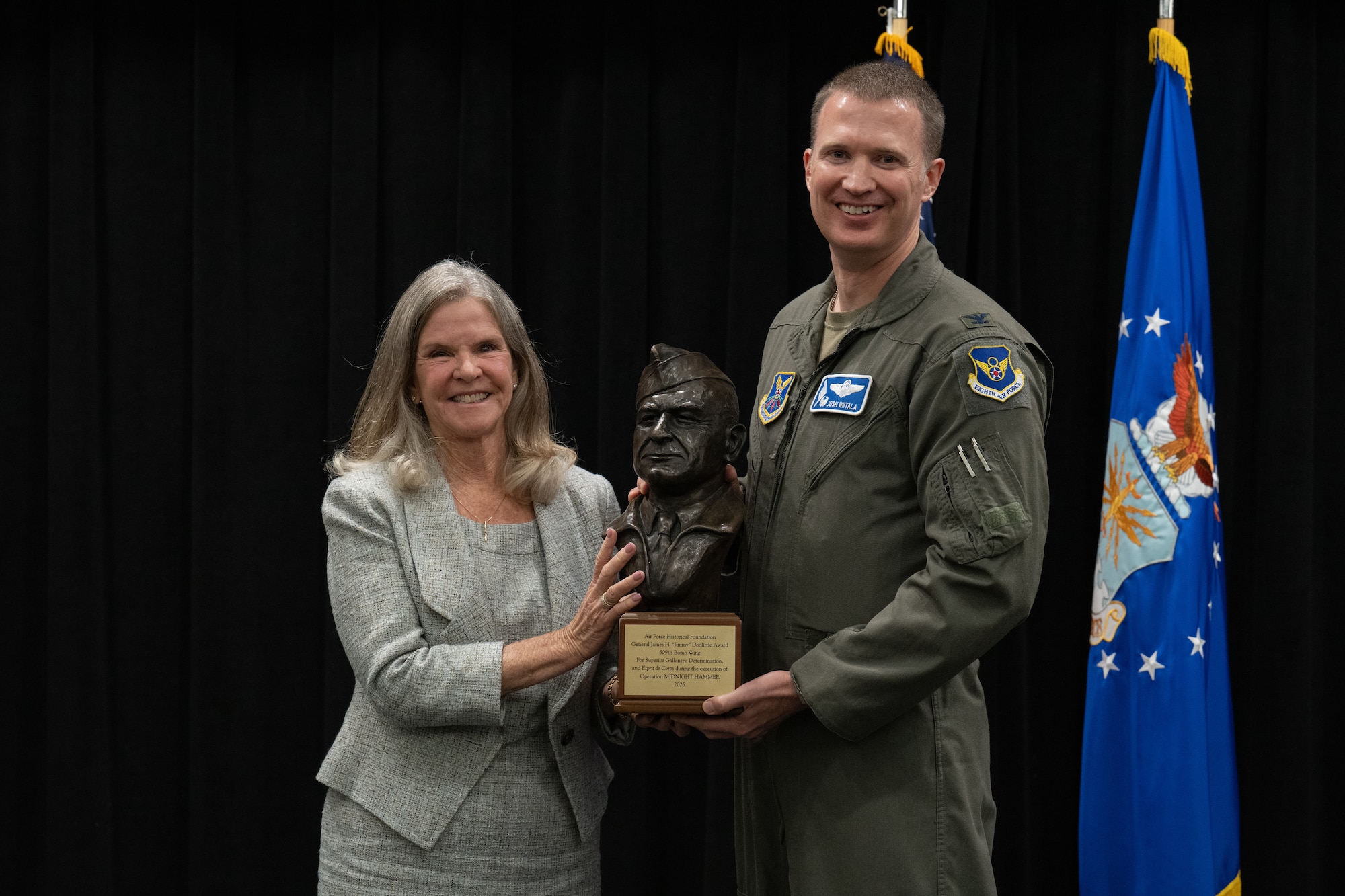 Jonna Doolittle Hoppes, left, presents U.S. Air Force Col. Joshua Wiitala, 509th Bomb Wing commander, with the Air Force Historical Foundation's 2025 James H. "Jimmy" Doolittle Award at Whiteman Air Force Base, Missouri, July 28, 2026. The award recognizes an active Air Force or Space Force unit for gallantry, determination, esprit de corps, and superior management of joint operations in accomplishing its mission under difficult and hazardous conditions in multiple conflicts. (U.S. Air Force photo by Senior Airman Matthew S. Domingos)