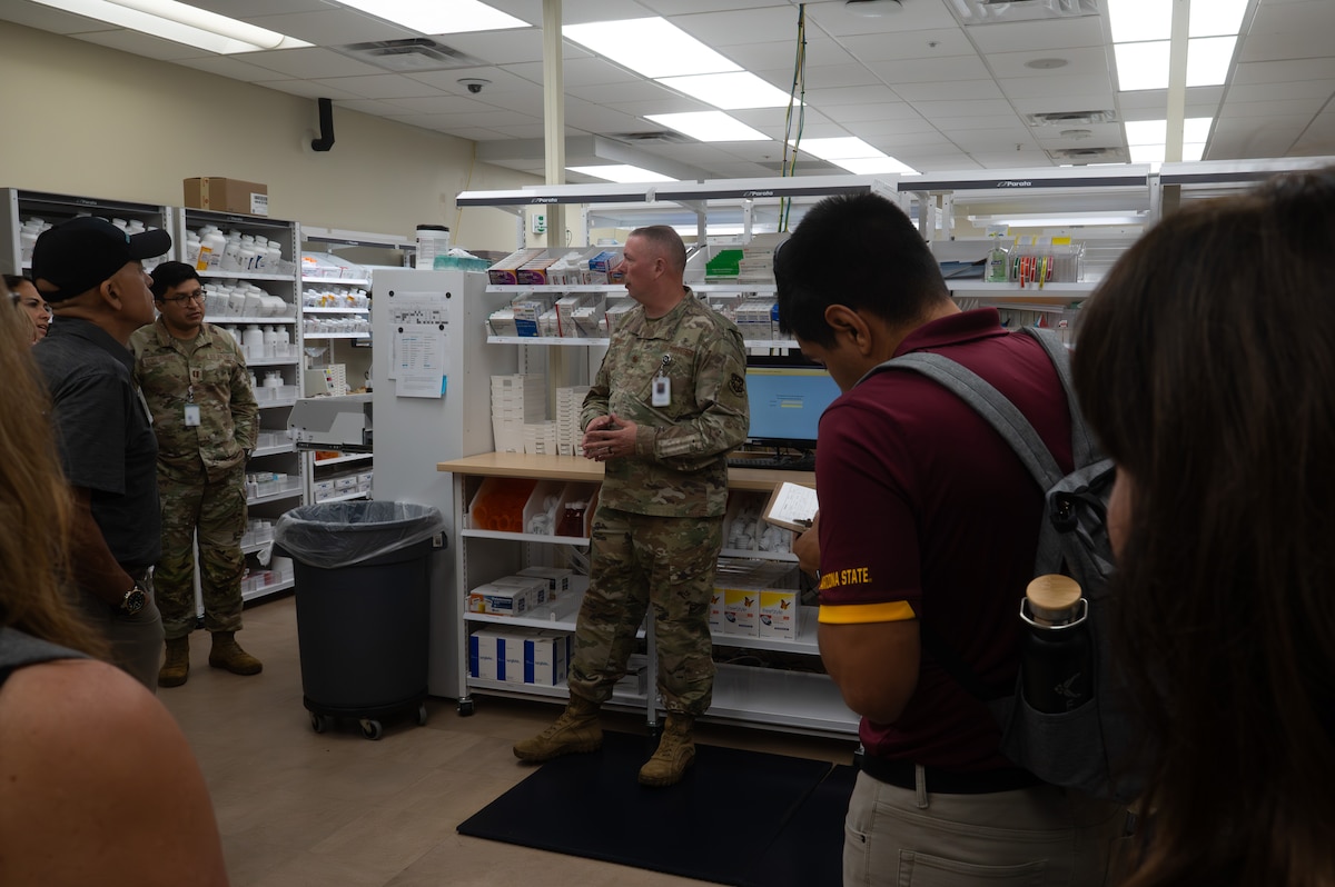 U.S. Air Force Maj. Joshua Wiser, Goodfellow Medical Group Diagnostics and Therapeutics flight commander, briefs participants during the Distinguished Educators’ Tour inside the Ross Clinic pharmacy, Goodfellow Air Force Base, Texas, July 21, 2026. The pharmacy is one of many offices within the GMDG that ensures TRICARE beneficiaries are fully prepared for wartime and daily operations through high-quality, patient-centered health services. (U.S. Air Force photo by Senior Airman Brian Lummus) Portions of this image were blurred for OPSEC purposes.