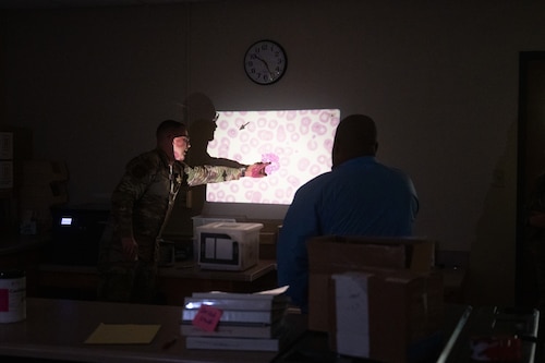 U.S. Air Force 1st Lt. Christopher Bedics, Goodfellow Medical Group laboratory element chief, and Staff Sgt. Justin Turner, GMDG laboratory noncommissioned officer in charge, showcase the different cells found in blood during the Distinguished Educators’ Tour inside the Ross Clinic laboratory, Goodfellow Air Force Base, Texas, July 21, 2026. Laboratory technicians need a high attention to detail to quantify and classify cells and their abnormalities. (U.S. Air Force photo by Senior Airman Brian Lummus) Portions of this image were blurred for OPSEC purposes.