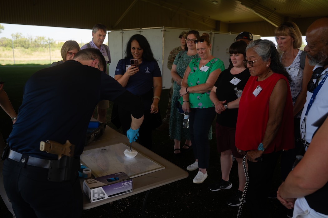 Investigator Jonathan Leblanc, 17th Security Forces Squadron investigations noncommissioned officer in charge, showcases fuming during the Air Distinguished Educators’ Tour at the military working dog kennels, Goodfellow Air Force Base, Texas, July 21, 2026. Fuming is a process used in forensics to find hidden fingerprints by using chemicals that react with the natural oils found on a person’s hands. (U.S. Air Force photo by Senior Airman Brian Lummus)