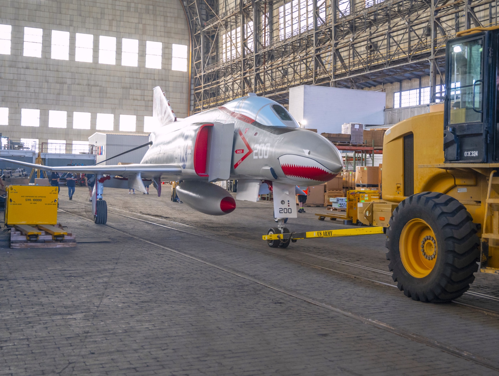 A newly restored F-4 Phantom II military aircraft is transported out of Hangar 1 to its new location as a static display in Navy Lakehurst Air Park at Joint Base McGuire-Dix-Lakehurst, N.J., July 1, 2026. The restoration, which took 13 months to complete, was accomplished by a team of 13 volunteers that included Airmen, Sailors, retired veterans, members of the Navy Lakehurst Historical Society and other civilians. (U.S. Air Force photo by Susan Moriarty)
