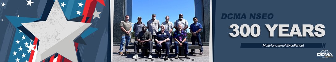 A group poses for a photo in front of a war memorial