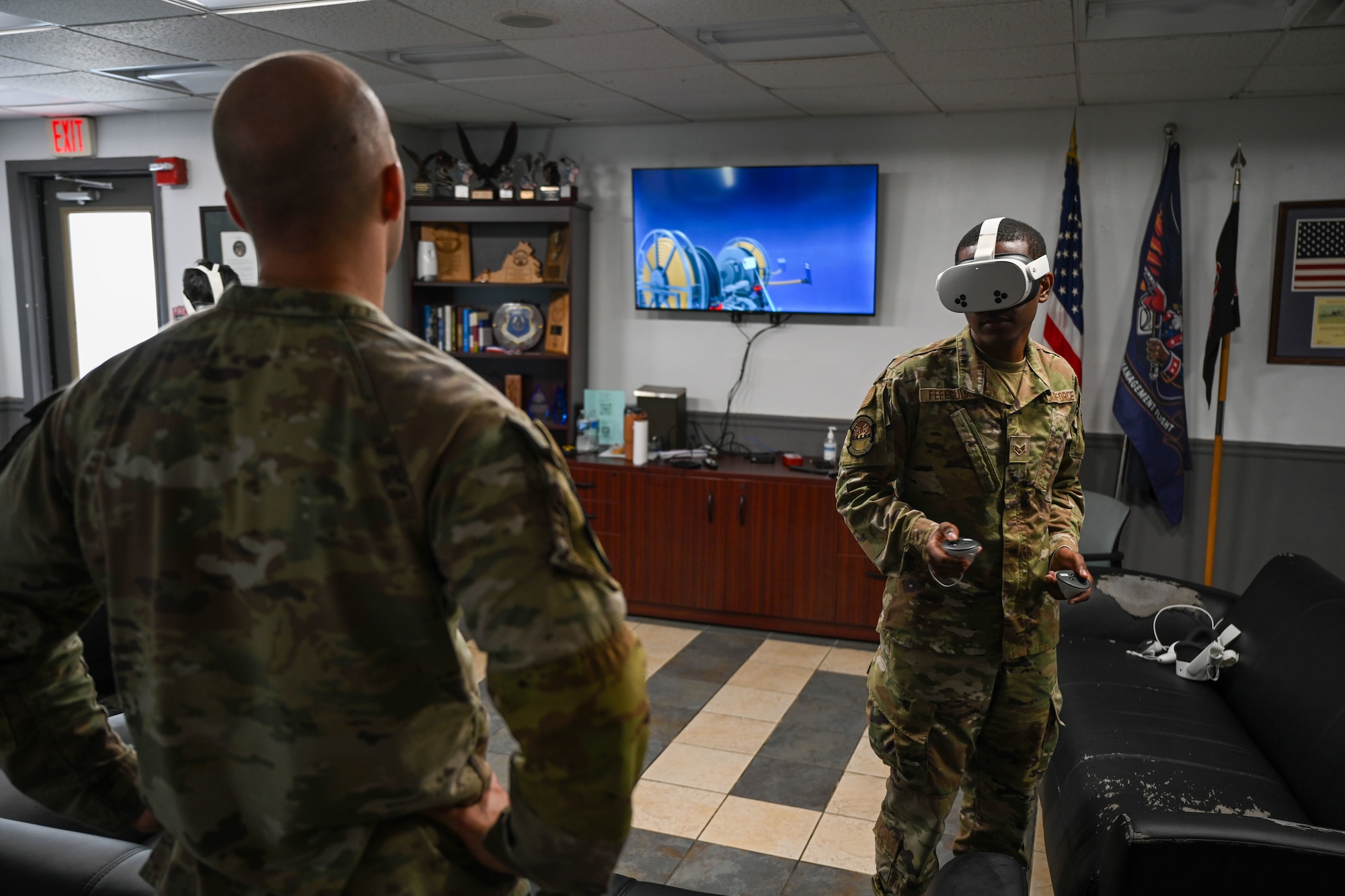 An Airman watches another Airman use virtual reality gear. (U.S. Air Force photo by Airman 1st Class Donnell Ramsey)