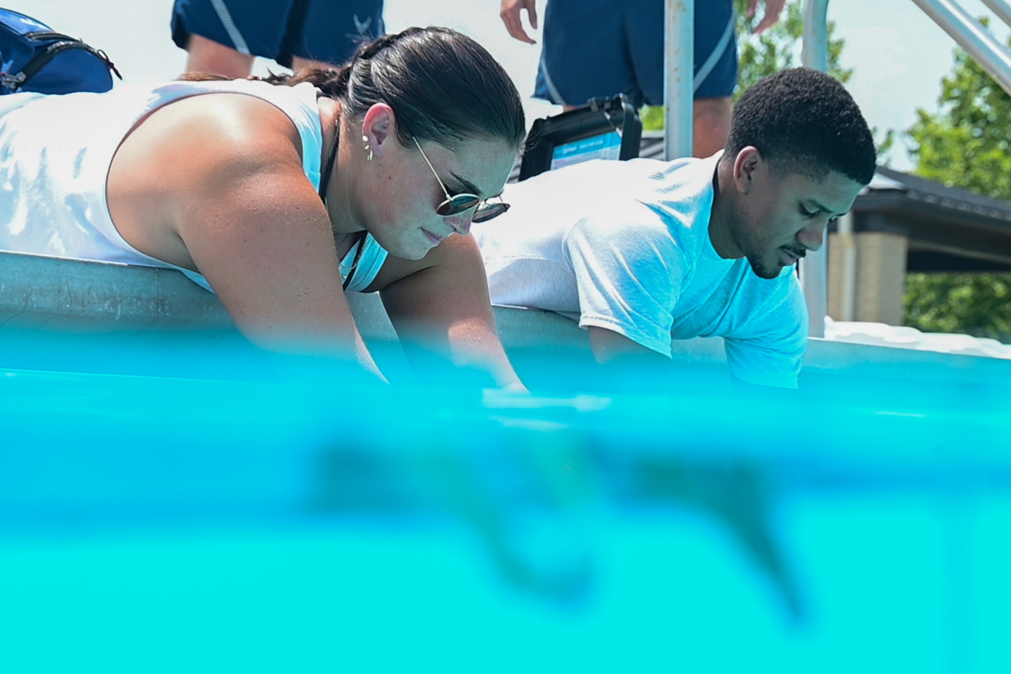 Allison Hemberger, left, 436th Force Support Squadron aquatic supervisor, and Airman 1st Class Malachi Reape, 436th Health Care Operations Squadron medical technician, test pH and chlorine levels during a Dover Duties visit to the Oasis Pool at Dover Air Force Base, Delaware, July 15, 2026. The visit offered  hands-on experience with the day-to-day efforts required to operate the recreational facility. Reape noted one similarity between his own job and being a lifeguard was the daily safety checklist that must be performed before the start of the day.
(U.S. Air Force photo by Mauricio Campino)