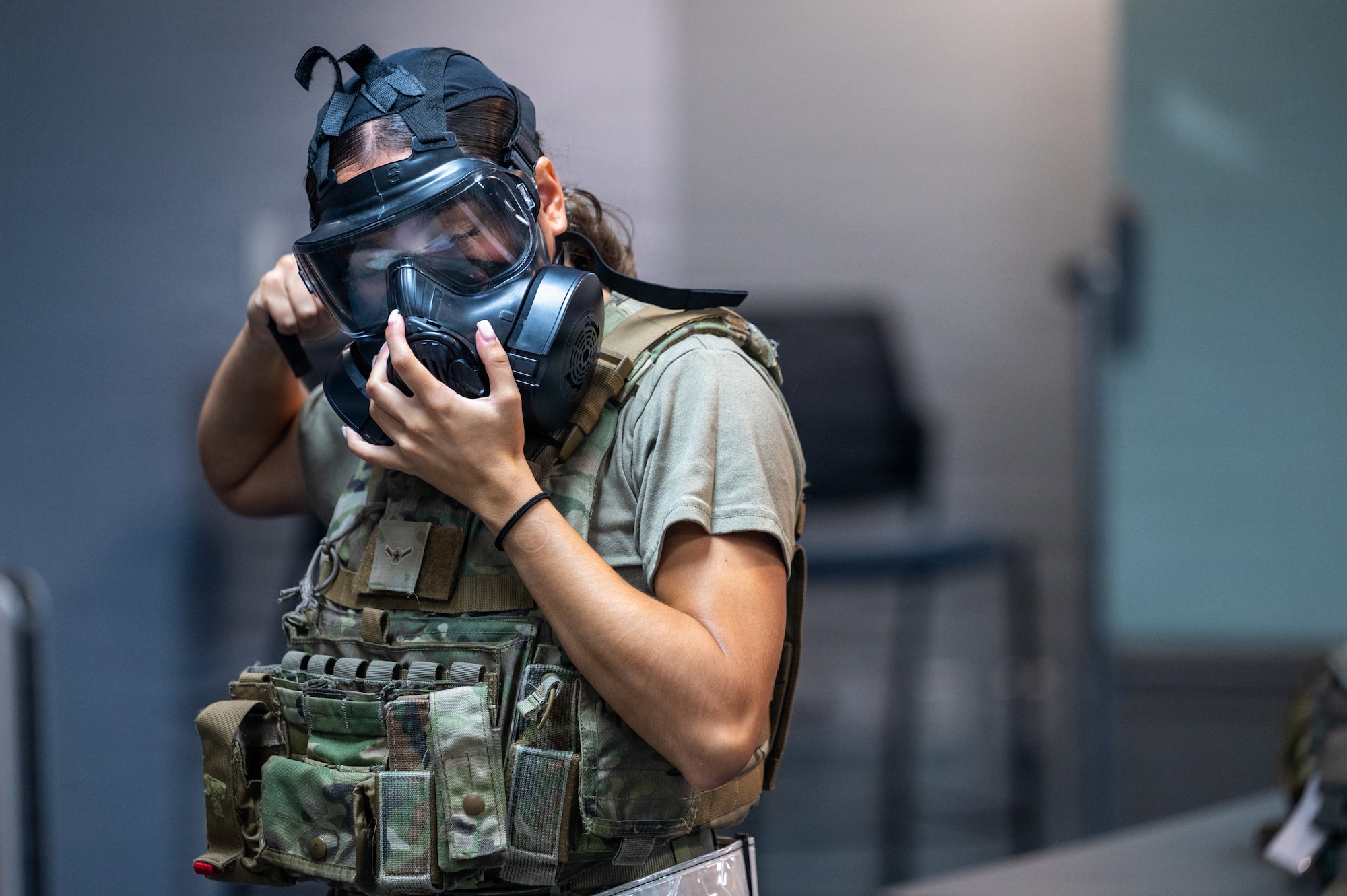 Airman puts gas mask on