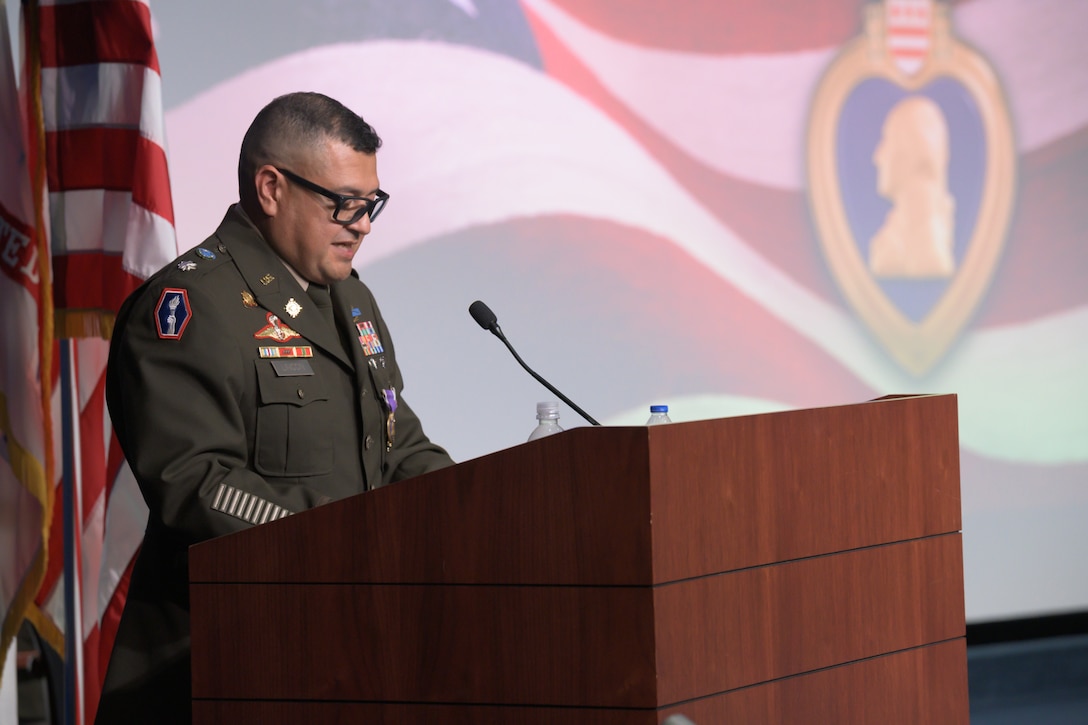 A male Army officer speaks at a podium during a ceremony.