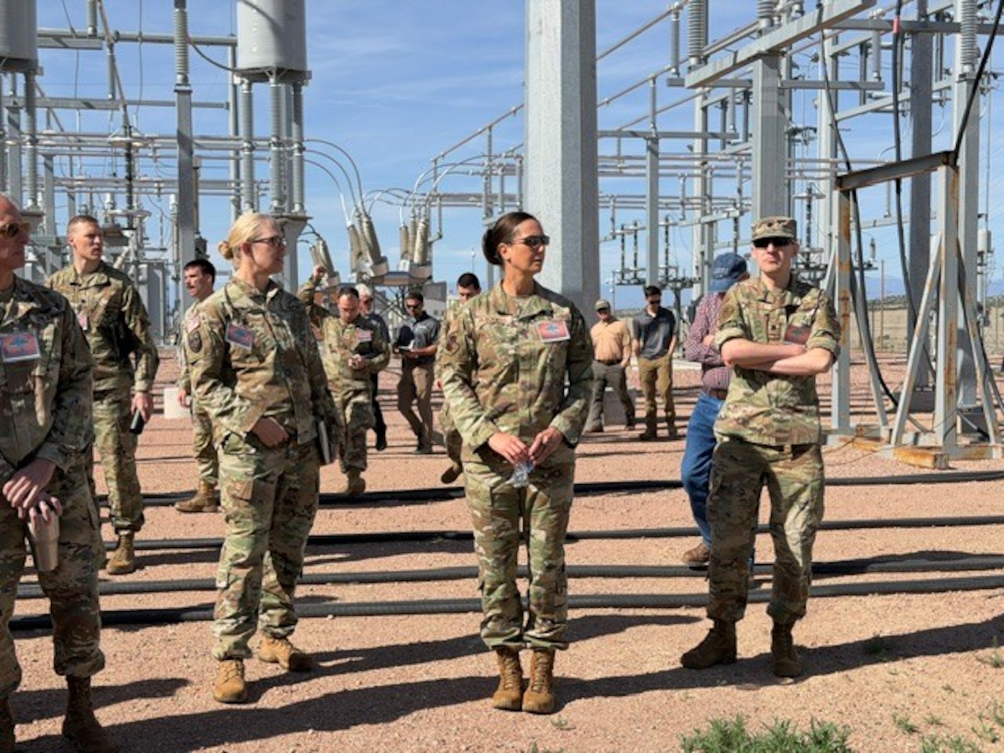 16th Air Force leadership stands in front of an electric grid.