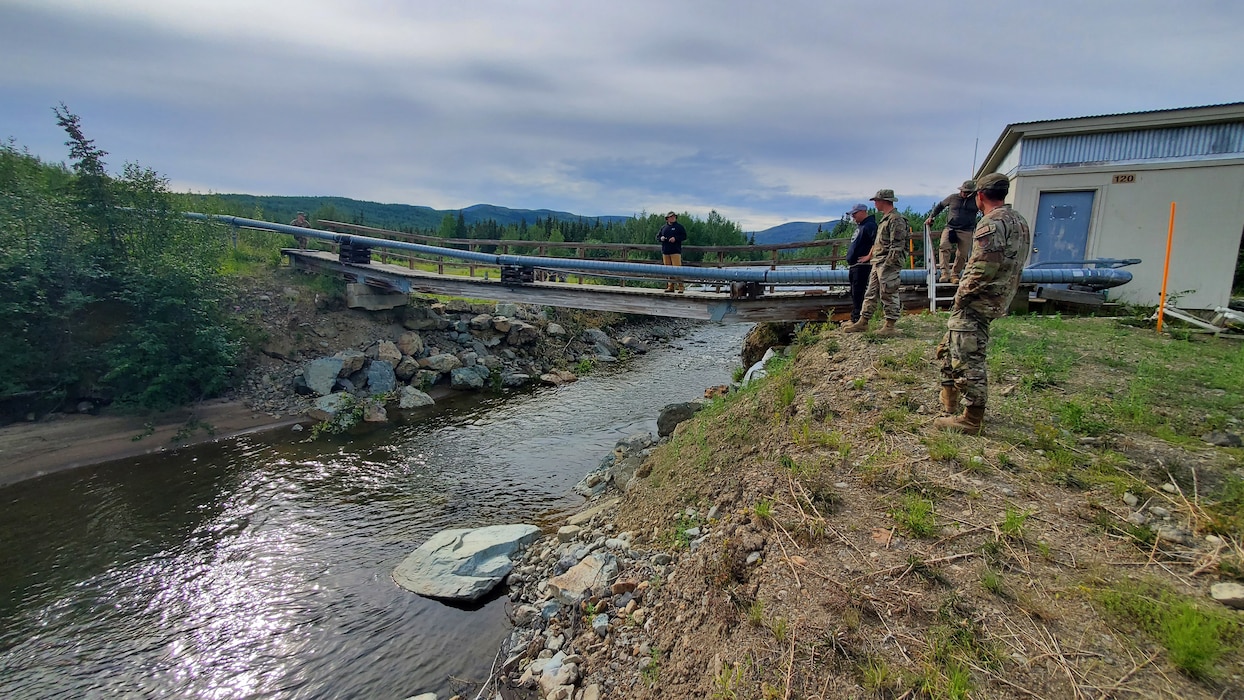 people stand near a bridge