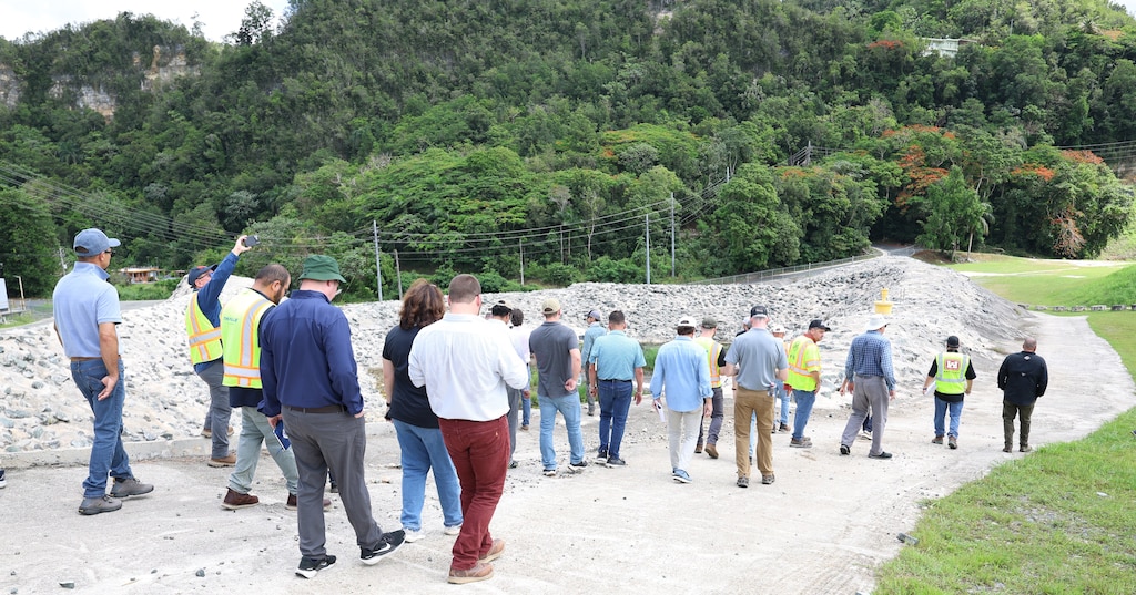 Contractors and USACE employees walk the Guajataca Dam during an on site review of upcoming repair work. The site visit allowed participants to examine existing conditions and understand the scale of the permanent repair project. The walk through was part of the second day of the outreach event, which took place July 28-29, 2026, to give contractors a firsthand look at project challenges.
