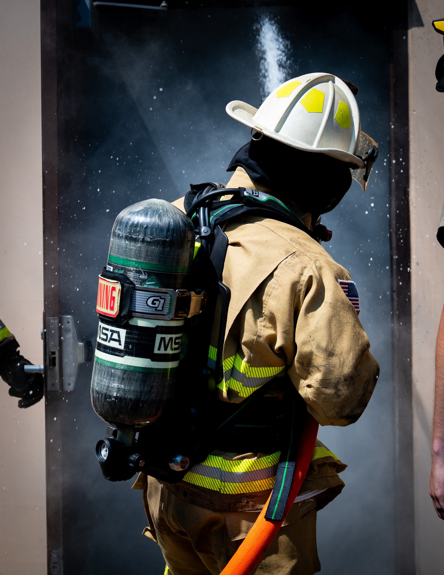 A photo of a fireman using a fire hose.