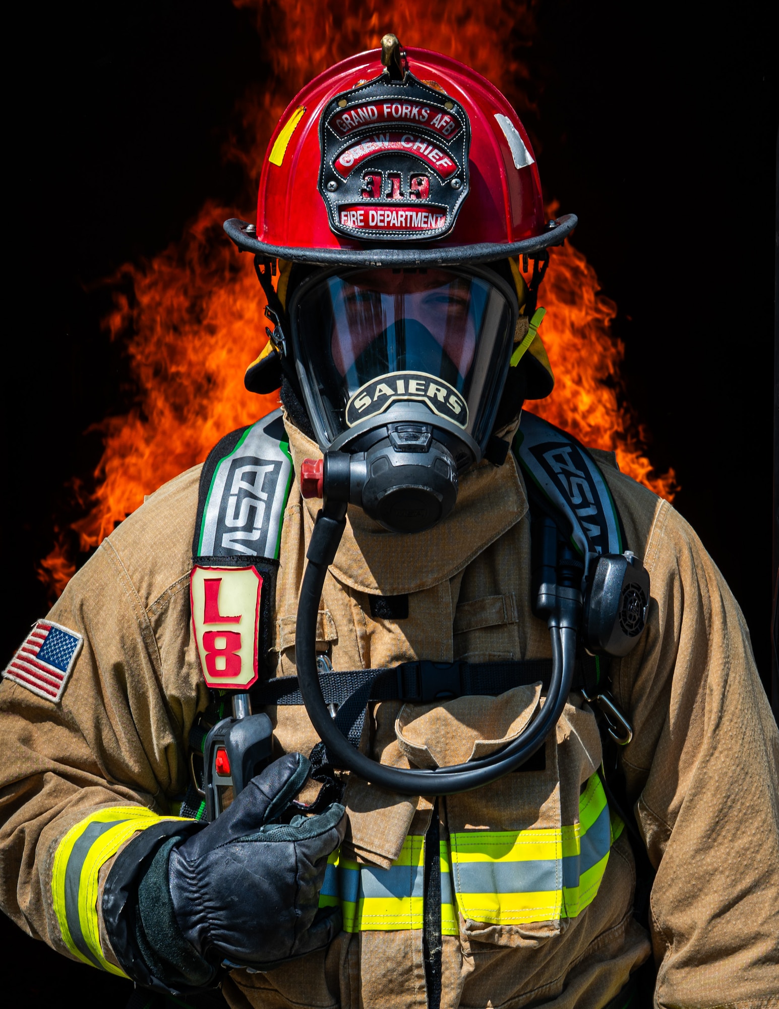 A photo of a fireman standing in front of a fire.