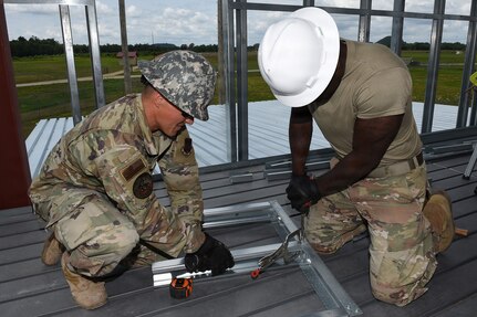Airmen from the 159th Civil Engineering Squadron, Louisiana Air National Guard, assemble a door frame for installation inside a fire training tower at Volk Field Combat Readiness Training Center, Camp Douglas, Wisconsin, July 21, 2026.