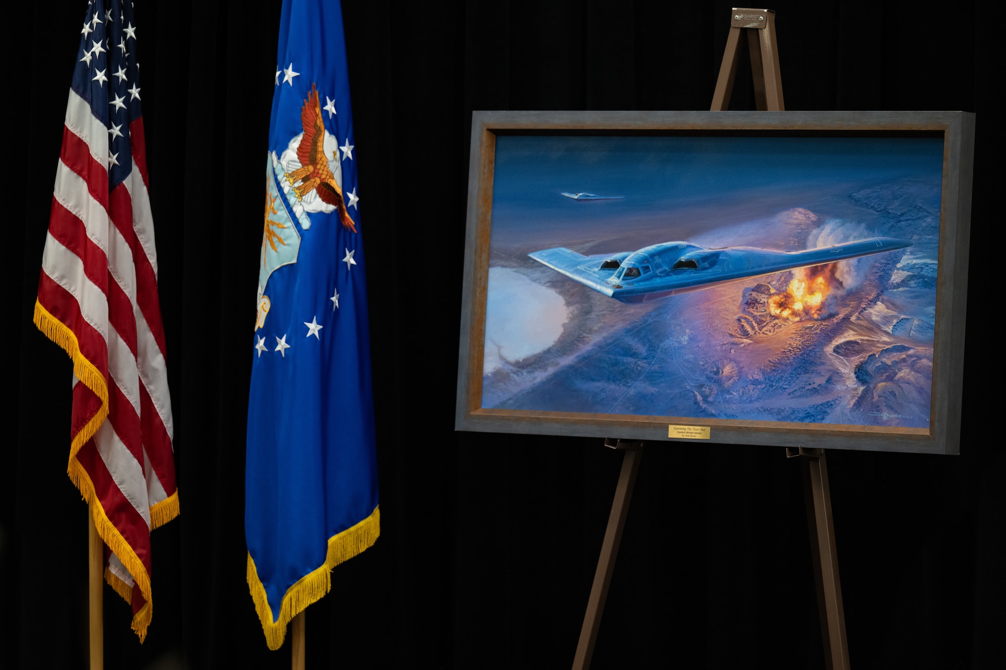 “Slamming the Door Shut,” a painting by Rick Herter depicting B-2 Spirit aircraft executing Operation Midnight Hammer, is shown on an easel at Whiteman Air Force Base, Missouri, July 28, 2026. Operation Midnight Hammer demonstrated Team Whiteman’s global strike capabilities as seven B-2 Spirit aircraft flew an 18-hour mission from Whiteman AFB to strike deep-buried Iranian nuclear sites. (U.S. Air Force photo by Senior Airman Matthew S. Domingos)