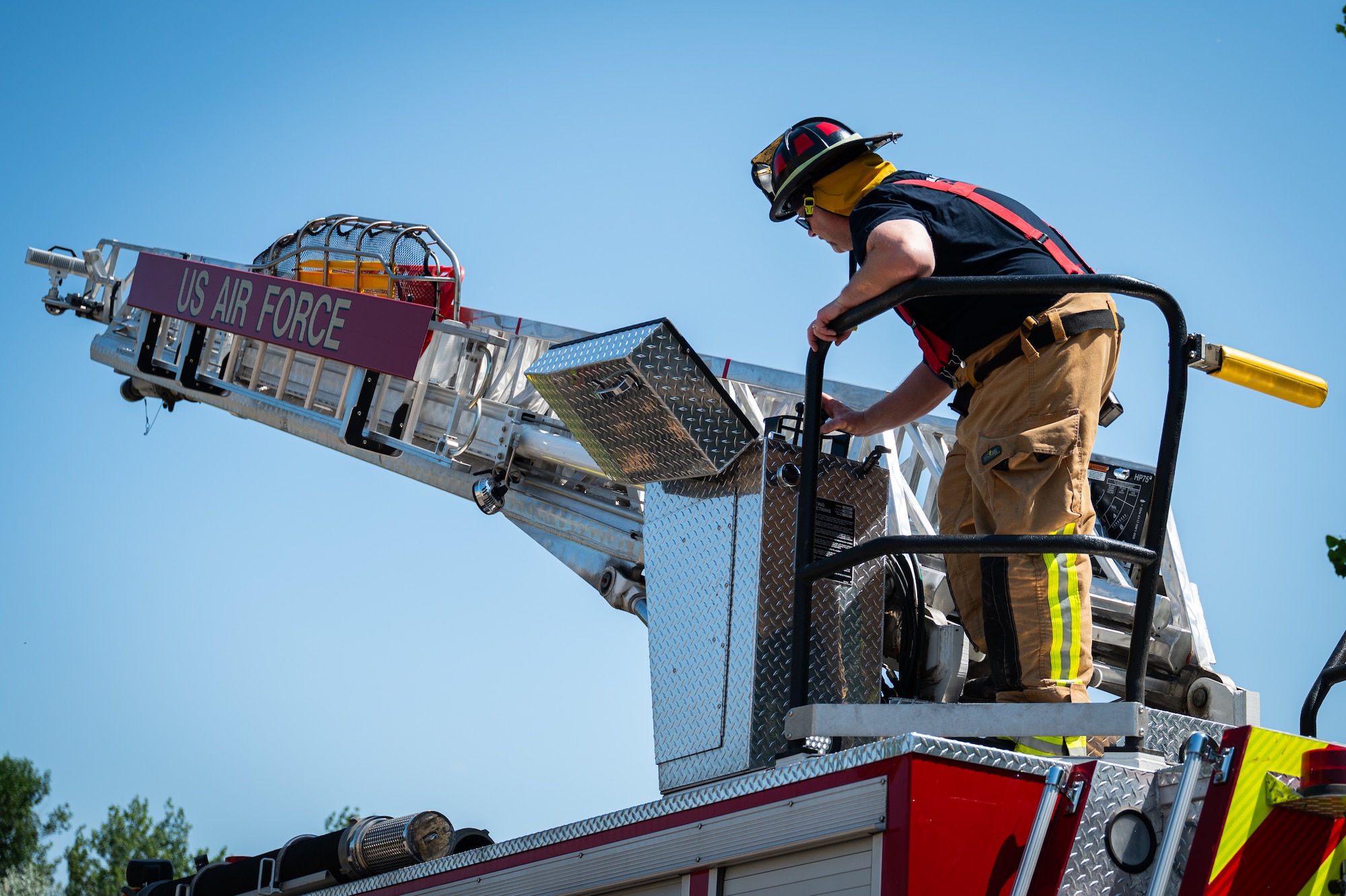 A photo of a fireman standing on a firetruck.