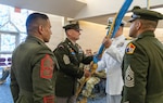 USMEPCOM  Western Sector commander, Navy Capt. Christopher Carmichael, passes the unit guidon to Army Command Sgt. Maj. David Goins during a change of responsibility and retirement ceremony July 30. Army Command Sgt. Maj. Ivan Martinez accepted responsibility as the new senior enlisted advisor of USMEPCOM Western Sector, succeeding Army Command Sgt. Maj. David Goins.