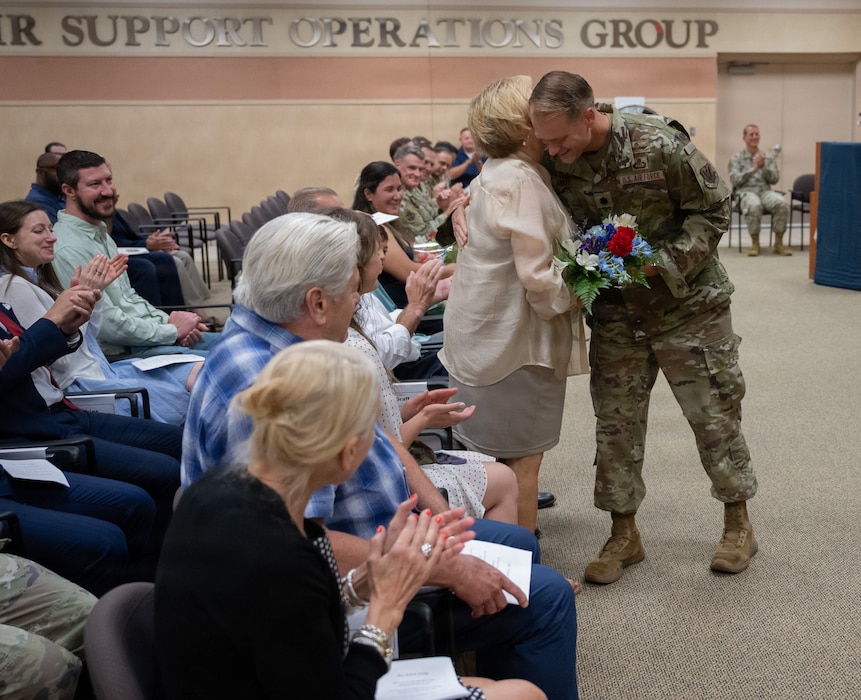 Commander presenting flowers to his family.