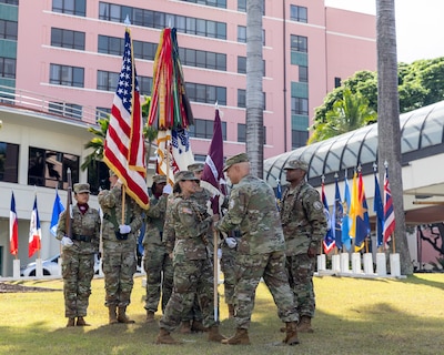 U.S. Army Col. William F. Bimson, right, director of Tripler Army Medical Center (TAMC), presents the unit colors to U.S. Army Command Sgt. Maj. Renee M. Butler, left, incoming command sergeant major of TAMC, during the change of responsibility ceremony at Constitution Park, July 29. (Defense Health Agency photo by Crizalmer Caraang Jr.)