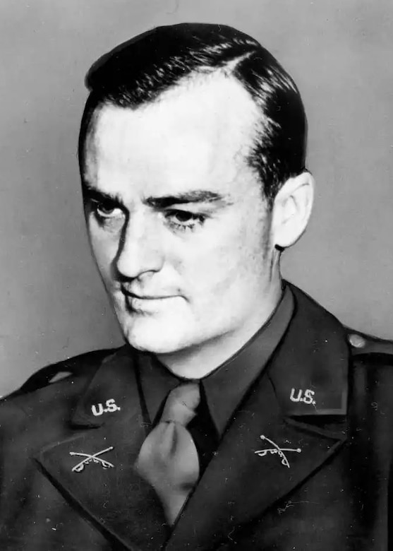 A man wearing a formal military uniform poses for a portrait.