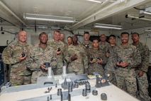 U.S. Marines with 3rd Maintenance Battalion, Combat Logistics Regiment 35, 3rd Marine Logistics Group, and Coast Guardsmen with Port Security Unit 309 pose for a group photo during a 3D printing capabilities showcase following Combined Joint Logistics Over-the-Shore 26 in Pohang, South Korea, July 17, 2026. The Marines demonstrated 3D printing capabilities to members of the Coast Guard’s Port Security Unit 309 as part of an effort to foster technological familiarization and strengthen joint logistical operations capabilities between Marines and Coast Guardsmen. CJLOTS 26 was a combined exercise designed to integrate U.S. and Republic of Korea lighterage and ship-to-shore connector capabilities, improve combined readiness, strengthen the Republic of Korea-U.S. alliance, and expand combined maritime sustainment capacity during logistics operations. (U.S. Marine Corps photo by Lance Cpl. Marcus Henson)