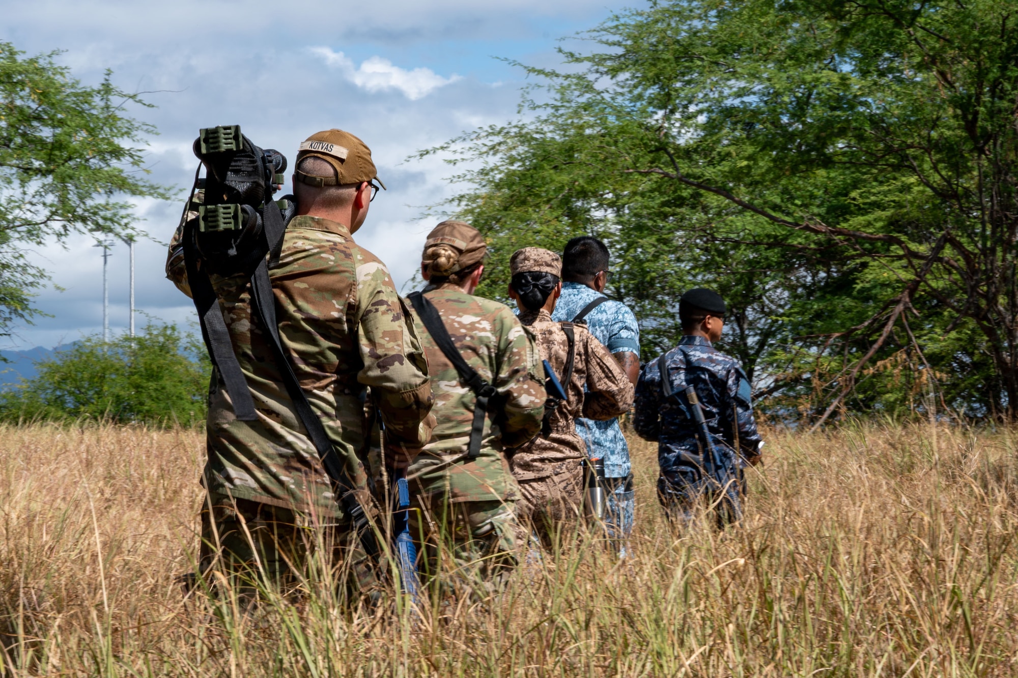 Multinational airmen walking through a field