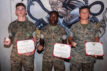 From left to right, U.S. Marine Corps Lance Cpl. Zachary Leewe, Pfc. Marvin Bousy, and Lance Cpl. Braeden Martinez, all bulk fuel specialists with Bulk Fuel Company, 9th Engineer Support Battalion, 3rd Marine Logistics Group, pose after receiving Navy and Marine Corps Achievement Medals and challenge coins in recognition for their bystander intervention actions at Camp Hansen, Okinawa, Japan, on July 23, 2026. On July 5, the Marines were on liberty at Naminoue Beach when they intervened in an assault between two civilians, rendering medical aid to the victim and preventing further violent actions from occurring until local police arrived on the scene.