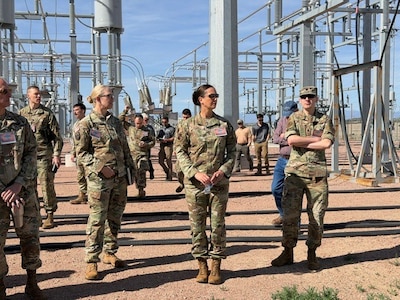 16th Air Force leadership stands in front of an electric grid.